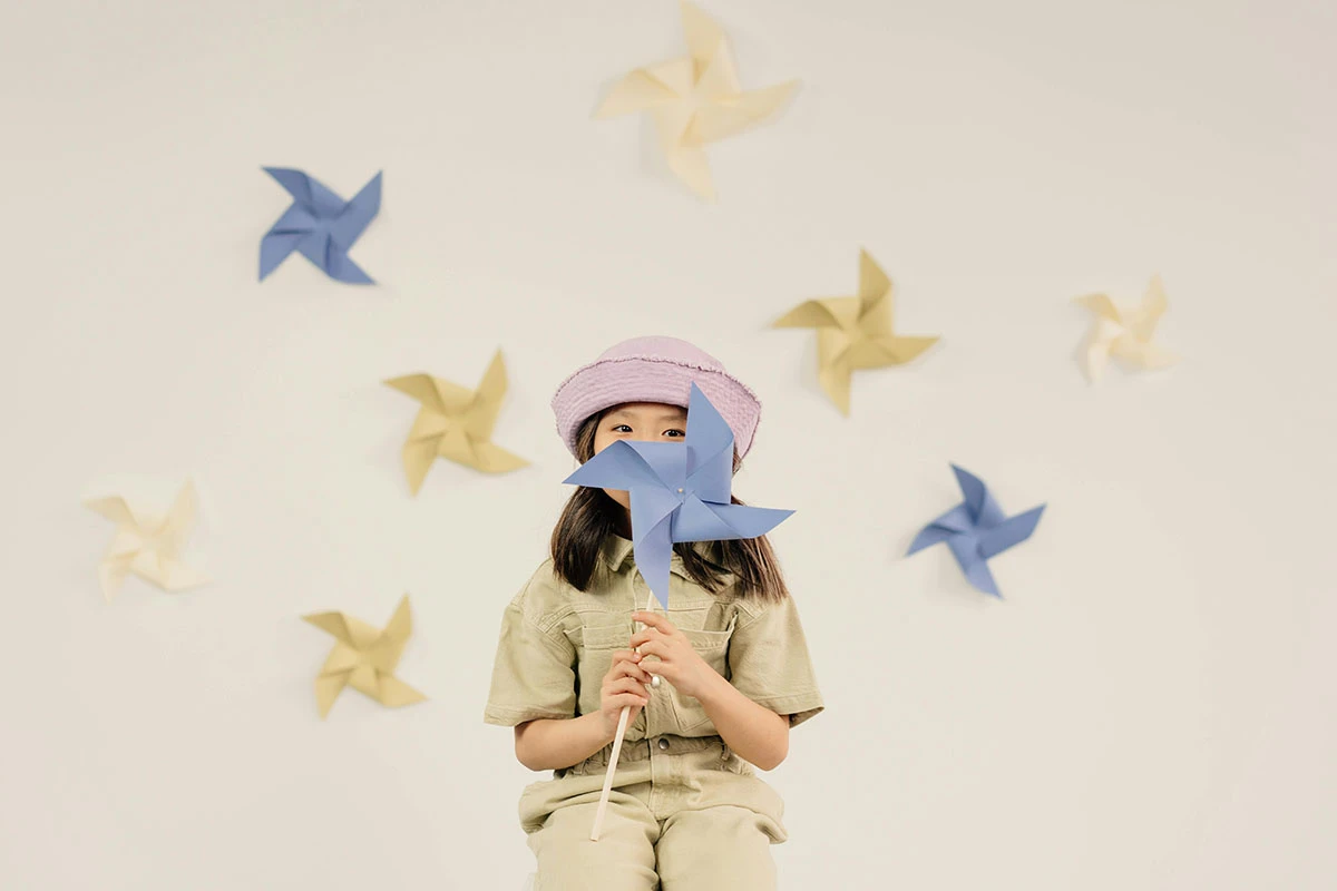 Seorang anak perempuan memegang kipas origami