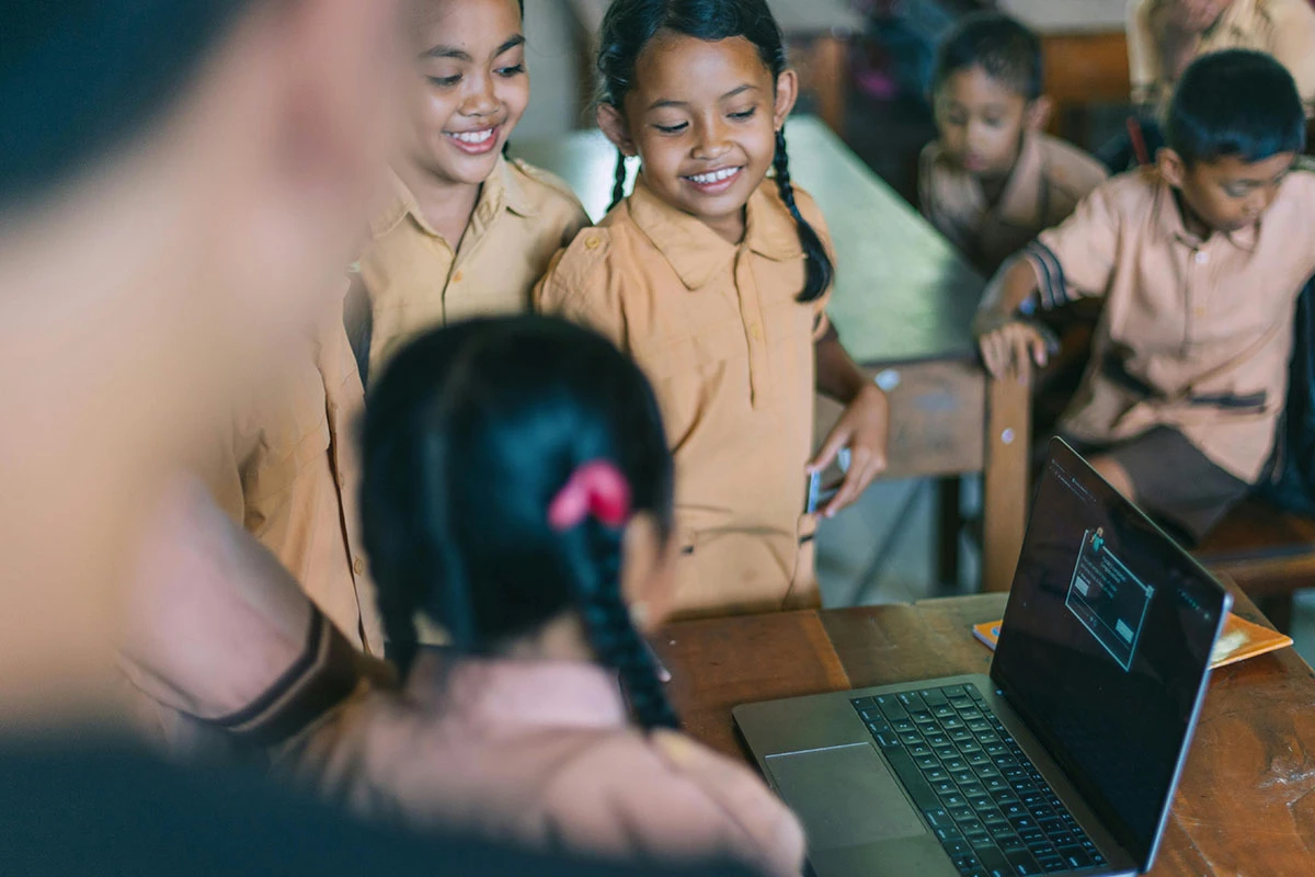 Murid sekolah sedang menggunakan laptop bersama-sama